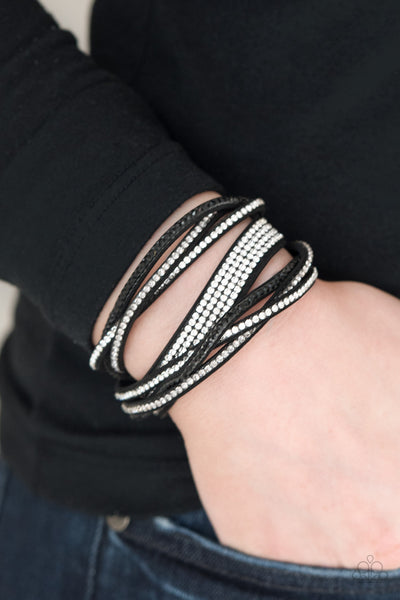 Taking Care Of Business - Black Bracelet - Paparazzi Accessories An elongated black suede band is encrusted in sections of braided white, smoky, and black rhinestones and rows of neatly stacked white rhinestones. The elongated band double wraps around the wrist for a fierce one-of-a-kind look. Features an adjustable snap closure.  Sold as one individual bracelet.  New Kit