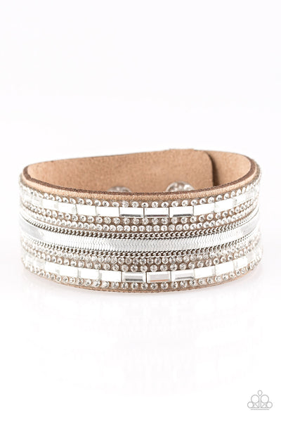 Teasingly Tomboy - Brown Bracelet - Paparazzi Accessories Mismatched silver chains, glassy emerald-cut, and glittery white rhinestones are encrusted along a thick brown suede band for a sassy look. Features an adjustable snap closure.  Sold as one individual bracelet.