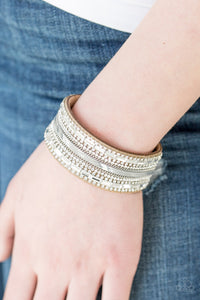 Teasingly Tomboy - Brown Bracelet - Paparazzi Accessories Mismatched silver chains, glassy emerald-cut, and glittery white rhinestones are encrusted along a thick brown suede band for a sassy look. Features an adjustable snap closure.  Sold as one individual bracelet.