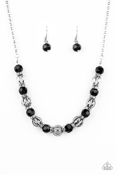 Metro Majestic - Black Necklace - Paparazzi Accessories A collection of airy silver beads, glittery black rhinestone beads, and white rhinestone encrusted rings are threaded along an invisible wire below the collar for a statement-making fashion. Features an adjustable clasp closure.  Sold as one individual necklace. Includes one pair of matching earrings.