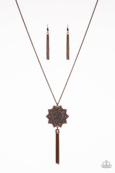 From Sunup To Sundown - Copper Necklace - Paparazzi Accessories A textured sunburst pendant swings from the bottom of a lengthened copper chain. A shimmery copper chain tassel swings from the bottom of the tribal inspired pendant for a seasonal finish. Features an adjustable clasp closure.  Sold as one individual necklace. Includes one pair of matching earrings.