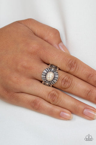 Thirst Quencher - White Ring - Paparazzi Accessories An oval white stone is pressed into the center of an ornate silver frame radiating with linear and sunburst patterns for a seasonal flair. Features a dainty stretchy band for a flexible fit.  Sold as one individual ring.