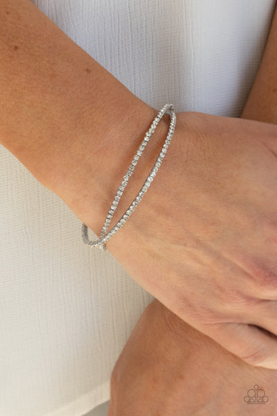 Plus One Status - White Bracelet - Paparazzi Accessories Radiant rows of glassy white rhinestones delicately intertwine into an airy silver cuff around the wrist, creating a glamorous sparkle.  Sold as one individual bracelet.  New Kit