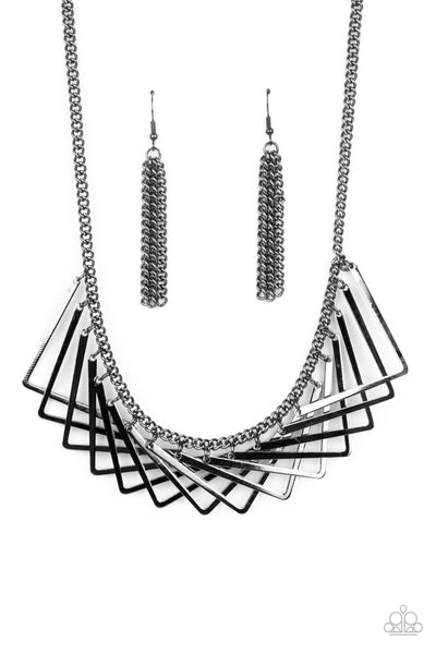 Metro Mirage - Black Necklace - Paparazzi Accessories A shiny collection of gunmetal V-shape frames delicately overlap below the collar, creating an edgy optical illusion. Features an adjustable clasp closure.  Sold as one individual necklace. Includes one pair of matching earrings.  New Kit