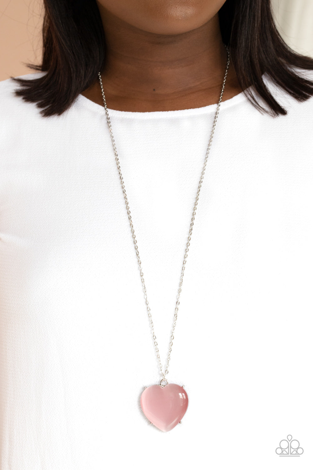 Warmhearted Glow - Pink Necklace - Paparazzi Accessories An oversized pink cat's eye stone frame swings from the bottom of a lengthened silver chain, creating a flirtatious pendant. Features an adjustable clasp closure.  Sold as one individual necklace. Includes one pair of matching earrings.  New Kit