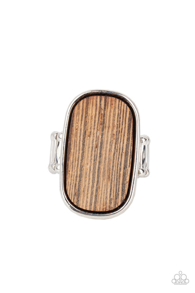 Reclaimed Refinement - Brown Ring - Paparazzi Accessories Encased in a sleek silver frame, a rustic piece of wood sits atop the finger for an unexpected refinement. Features a stretchy band for a flexible fit.  Sold as one individual ring.  New Kit