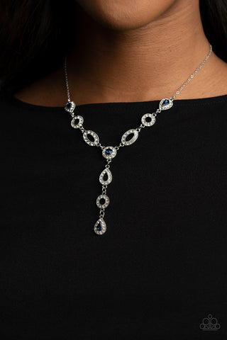 Royal Redux - Blue Necklace - Paparazzi Accessories White rhinestone encrusted oval and teardrop silver frames delicately link with matching blue rhinestone dotted frames below the collar. Matching frames trickle from the center, creating an elegant extended pendant. Features an adjustable clasp closure.  Sold as one individual necklace. Includes one pair of matching earrings.  New Kit