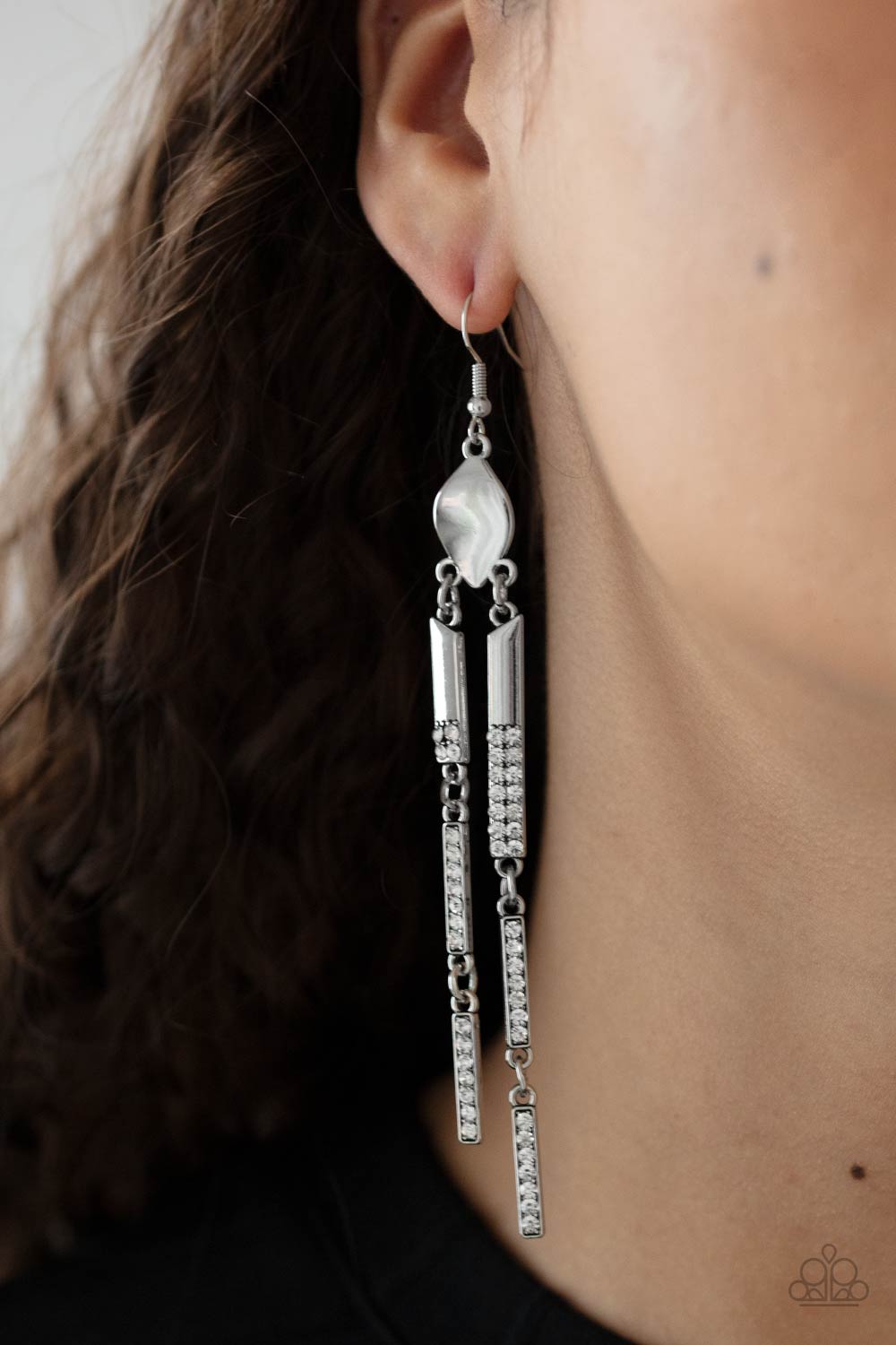 Defined Dazzle - White Earrings - Paparazzi Accessories Sections of dainty white rhinestones are encrusted along the fronts of rectangular silver frames that link from a warped metal fitting, creating an edgy tassel. Earring attaches to a standard fishhook fitting.  Sold as one pair of earrings.  New Kit