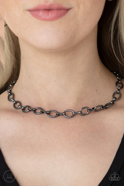 Craveable Couture - Black Choker Necklace - Paparazzi Accessories A collection of oversized gunmetal ovals and glistening gunmetal fittings interlock around the neck, creating an intense industrial look. Features an adjustable clasp closure.  Sold as one individual choker necklace. Includes one pair of matching earrings.  New Kit Choker