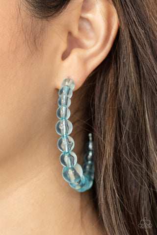 In The Clear - Blue Earrings - Paparazzi Accessories Gradually increasing in size at the center, a glassy collection of Cerulean beads are threaded along an oversized hoop for a bubbly effect. Earring attaches to a standard post fitting. Hoop measures approximately 2 1/2" in diameter.  Sold as one pair of hoop earrings.  New Kit