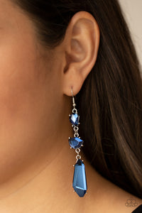 Sophisticated Smolder - Blue Earrings - Paparazzi Accessories Featuring raw cuts, an asymmetrical collection of faceted blue gems trickles from the ear, creating a smoldering chandelier. Earring attaches to a standard fishhook fitting.  Sold as one pair of earrings.  New Kit