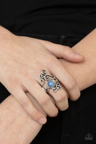 Glimmering Grapevines - Blue Ring - Paparazzi Accessories Rustic silver filigree vines around a glowing Cerulean cat's eye stone, creating a whimsically asymmetrical display across the finger. Features a stretchy band for a flexible fit.  Sold as one individual ring.  New Kit