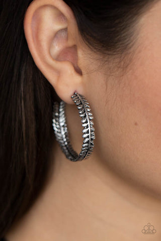 Laurel Gardens - Silver Hoop Earrings - Paparazzi Accessories Brushed in an antiqued shimmer, a leafy silver frame delicately curls into a whimsical hoop. Earring attaches to a standard post fitting. Hoop measures approximately 1 1/4" in diameter.  Sold as one pair of hoop earrings.  New Kit