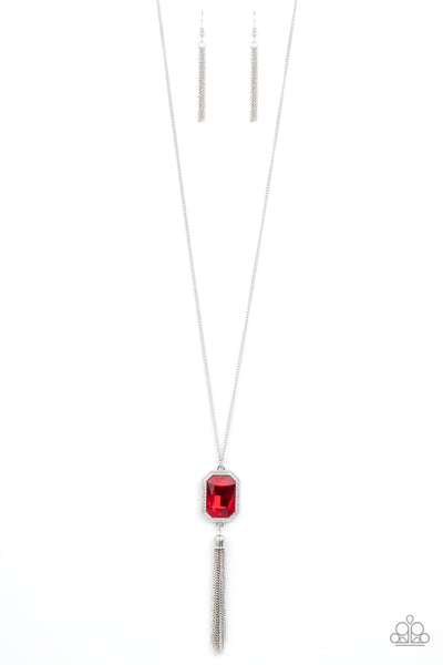 Blissed Out Opulence - Red Necklace - Paparazzi Accessories An impressive red emerald cut gem is pressed into the center of a silver studded frame, creating an ethereal pop of color at the bottom of a lengthened silver chain. A silver chain tassel swings from the bottom of the pendant, adding flirtatious movement to the opulent display. Features an adjustable clasp closure.  Sold as one individual necklace. Includes one pair of matching earrings.  New Kit