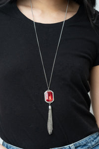 Blissed Out Opulence - Red Necklace - Paparazzi Accessories An impressive red emerald cut gem is pressed into the center of a silver studded frame, creating an ethereal pop of color at the bottom of a lengthened silver chain. A silver chain tassel swings from the bottom of the pendant, adding flirtatious movement to the opulent display. Features an adjustable clasp closure.  Sold as one individual necklace. Includes one pair of matching earrings.  New Kit