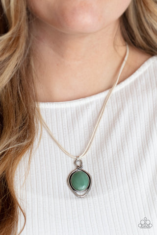 Desert Mystery - Green Necklace - Paparazzi Accessories An oversized jade stone is pressed into a silver oval frame, outlined with an unexpected irregular shaped frame. The eye-catching pendant suspends from a double strand of white cord below the collar for a mysterious finish. Features an adjustable clasp closure.  Sold as one individual necklace. Includes one pair of matching earrings.  New Kit