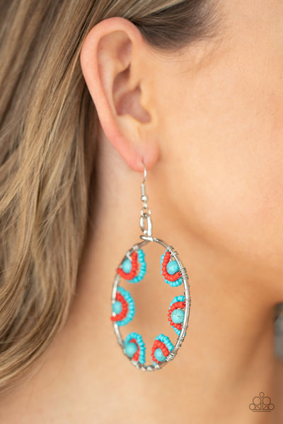 Off The Rim - Blue Earrings - Paparazzi Accessories Red and turquoise seed beads are threaded on wires and looped over turquoise stones on the inside of a spacious silver hoop. The pattern makes its way around the inside of the circle for an around-the-world air. Earring attaches to a standard fishhook fitting.  Sold as one pair of earrings.  New Kit