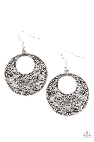 Vineyard Romance - Silver Earrings - Paparazzi Accessories Brushed in an antiqued shimmer, vine-like filigree silver climbs the inside of a studded circular frame, creating a whimsical centerpiece. Earring attaches to a standard fishhook fitting.  Sold as one pair of earrings.  New Kit