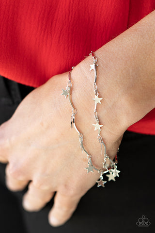 Party in the USA - Silver Bracelet - Paparazzi Accessories A collection of dainty silver stars and curved silver bars delicately connect around the wrist, creating a stellar fringe. Features an adjustable clasp closure.  Sold as one individual bracelet.   Get The Complete Look! Necklace: "Little Miss Americana - Silver" (Sold Separately)  New Kit