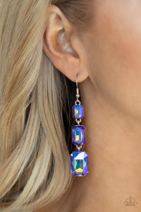 Cosmic Red Carpet - Blue Earrings - Paparazzi Accessories  Featuring a dazzling blue and gold UV shimmer, a trio of emerald-cut gems in graduating sizes is linked one below the other for a dramatic red carpet finish. Earring attaches to a standard fishhook fitting.  Sold as one pair of earrings.  New Kit