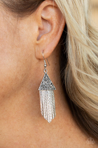 Pyramid SHEEN - Silver Earrings - Paparazzi Accessories Encrusted in dainty hematite rhinestones, a silver triangle frame gives way to a tapered fringe of flat silver chains for a smoldering effect. Earring attaches to a standard fishhook fitting.  Sold as one pair of earrings.  New Kit