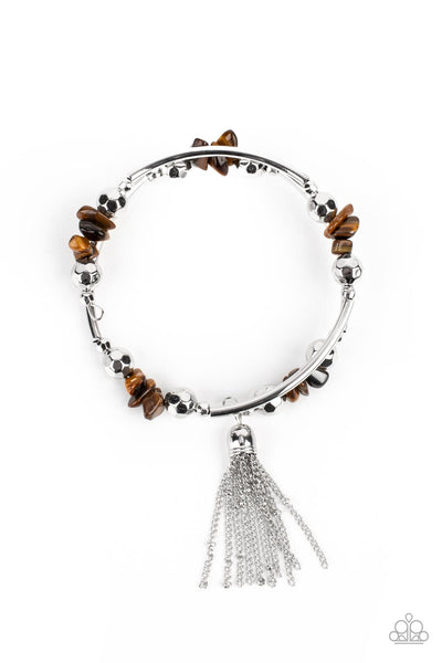 Mineral Mosaic - Brown Bracelet - Paparazzi Accessories  An earthy collection of faceted silver beads, raw cut tiger's eye rock beads, and cylindrical silver accents are threaded along a coiled wire around the wrist for a grounding pop of color. A shimmery silver chain tassel swings from one end of the spiral, adding a hint of flirtatious movement to the piece.  Sold as one individual bracelet.  New Kit