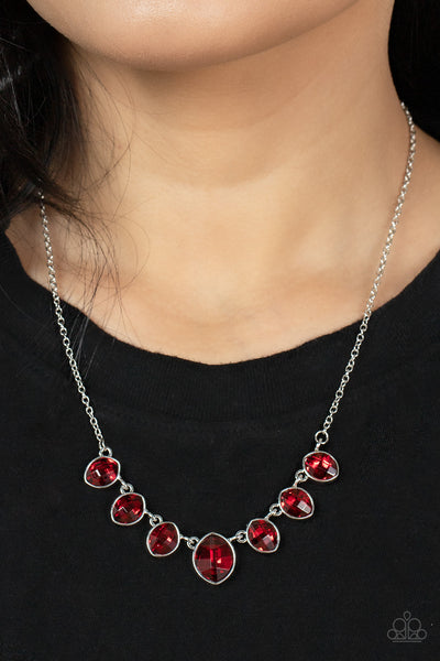 Material Girl Glamour - Red Necklace - Paparazzi Accessories Encased in sleek silver fittings, elegant cut fiery red rhinestones delicately connect below the collar. An oversized red rhinestone adorns to the middle of the glittery strand, creating a sparkly centerpiece. Features an adjustable clasp closure.  Sold as one individual necklace. Includes one pair of matching earrings.  New Kit