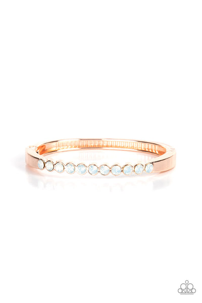 Mystical Masterpiece - Rose Gold Cuff Bracelet - Paparazzi Accessories An opalescent row of white rhinestones hinges to a glistening rose gold bar that curves around the wrist, creating a sparkly cuff-like bracelet. Features a hinged closure.  Sold as one individual bracelet.