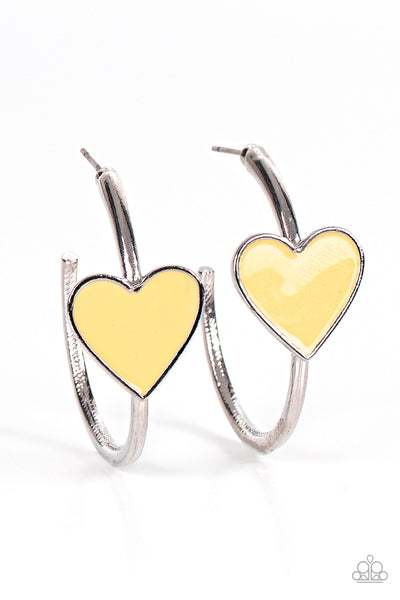 Kiss Up - Yellow Hoop Earrings - Paparazzi Accessories A charming Illuminating heart adorns the front of a classic silver hoop resulting in a whimsical fashion. Earring attaches to a standard post fitting. Hoop measures approximately 1 1/4" in diameter.  Sold as one pair of hoop earrings.  New Kit