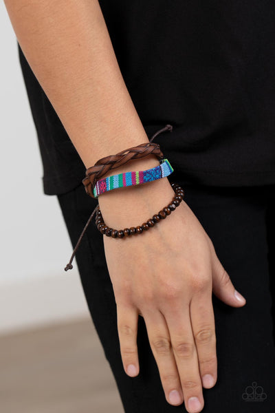 Textile Texting - Blue Bracelet - Paparazzi Accessories An earthy compilation of wooden beads, braided leather, and colorful textile fabric layers around the wrist for an adventurous fashion. Features an adjustable sliding knot closure.  Sold as one individual bracelet.