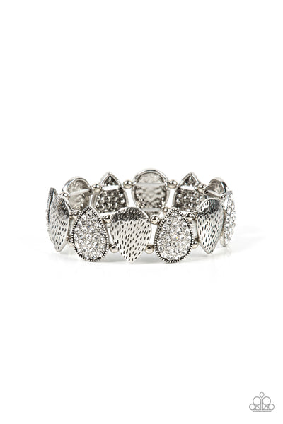 Playing Favorites - White Stretch Bracelet - Paparazzi Accessories Infused with pairs of silver beads, a decorative collection of hammered silver teardrops, and white encrusted silver teardrops alternate along stretchy bands around the wrist for an edgy flair.  Sold as one individual bracelet.  New Kit