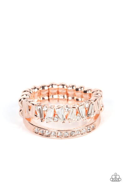 Fractal Fascination - Rose Gold Ring - Paparazzi Accessories Infused with a timeless band of white rhinestones, a dainty collection of trapezoidal cut white rhinestones staggers across the finger for a glamorously layered look. Features a dainty stretchy band for a flexible fit.  Sold as one individual ring.