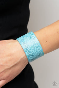 Rosy Wrap Up - Blue Bracelet - Paparazzi Accessories A flowery and leafy motif blooms across the front of a distressed blue leather band, resulting in a rustic floral centerpiece around the wrist. Features an adjustable snap closure.  Sold as one individual bracelet.  New Kit