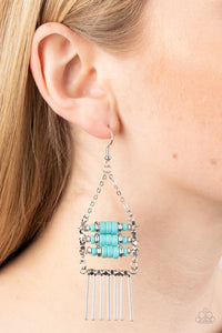 Tribal Tapestry - Blue Earrings - Paparazzi Accessories Rows of cylindrical silver and turquoise stone beads are threaded along metal rods between faceted silver cubes. Silver rods stream out from the bottom of the stacked display, resulting in an earthy fringe. Earring attaches to a standard fishhook fitting.  Sold as one pair of earrings.