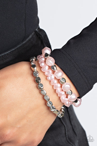 Shoreside Soiree - Pink Stretch Bracelet - Paparazzi Accessories Etched in natural inspired texture, oversized Gossamer Pink pearls alternate with faceted silver beads along a stretchy band around the wrist. The imperfect pearl centerpiece layers with a pair of faceted silver and Gossamer Pink pebble-like pearls, resulting in timeless layers.  Sold as one set of three bracelets.  New Kit