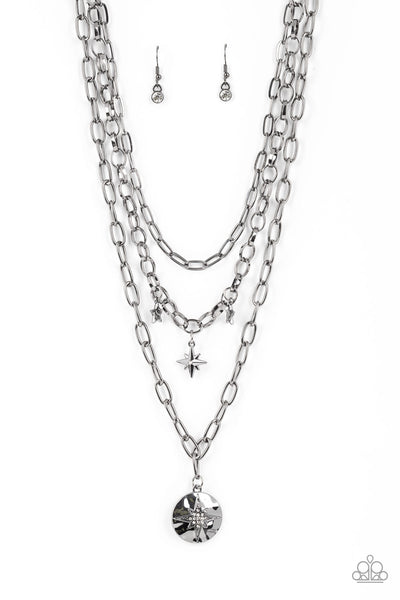 Under the Northern Lights - Black Necklace - Paparazzi Accessories Three gritty gunmetal chains layer down the chest. Flanked by a pair of hammered gunmetal stars, a white rhinestone dotted star swings from the centermost chain above a hammered gunmetal frame twinkling with a white rhinestone dotted star design for a stellar finish. Features an adjustable clasp closure.  Sold as one individual necklace. Includes one pair of matching earrings.